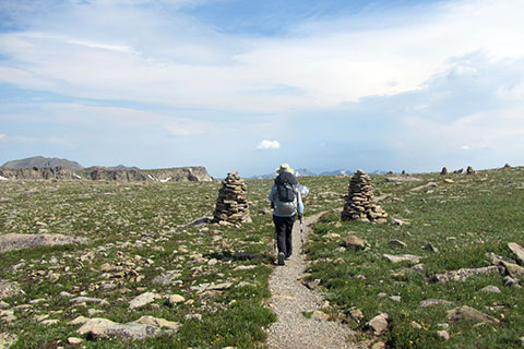 Flat terrain with tall cairns frame the hiker