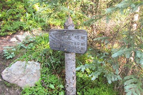 Wooden, trail directional sign at the Onahu Creek Trail Junction at the north end of Big Meadow
